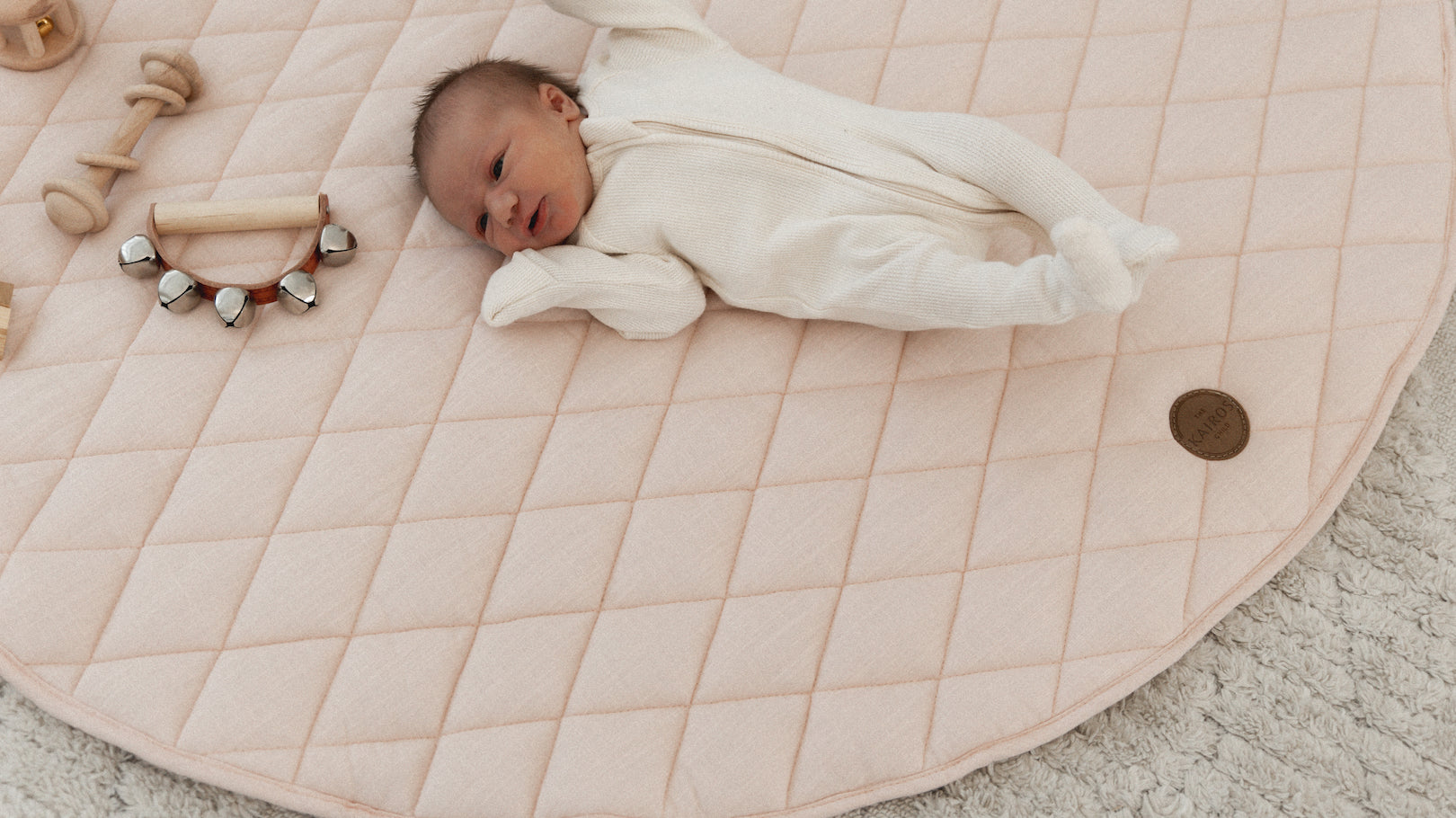 Baby stretching out on The Kairos Child's Positano play mat