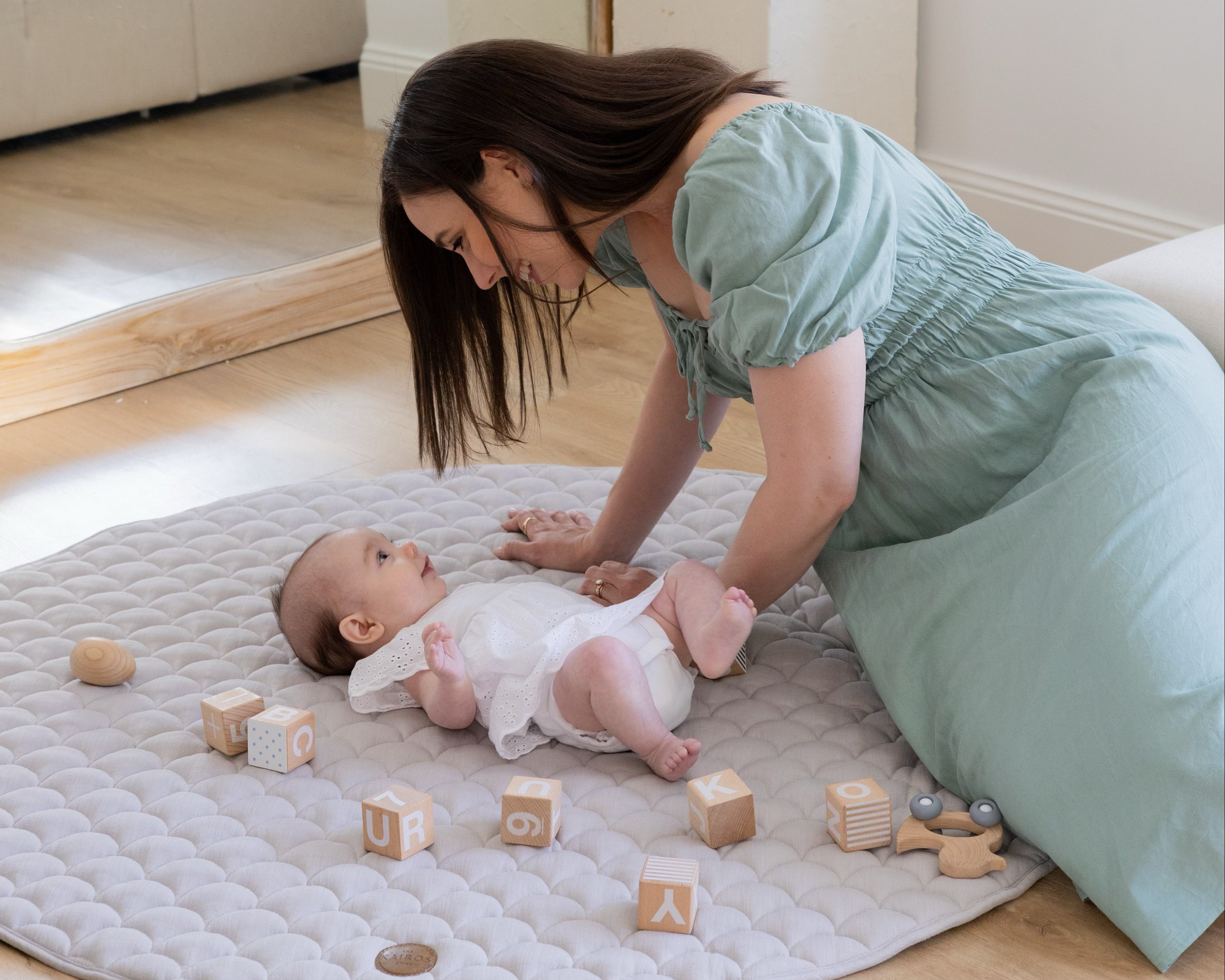 Mother having a connecting moment with baby on Caspian baby play mat